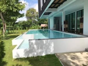 a swimming pool in the backyard of a house at Norden Barn B&B in Chiang Mai