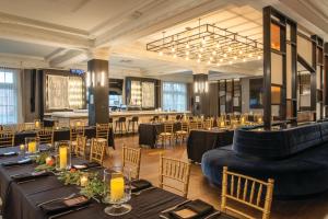 a restaurant with black tables and chairs and a bar at Aloft by Marriott Buffalo Downtown in Buffalo