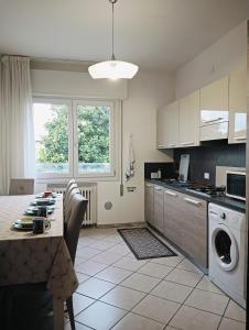 a kitchen with a table and a kitchen with a washing machine at Aaron guest house 1 in Marghera