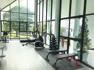 a gym with treadmills and ellipticals in a room with windows at Norden Barn B&B in Chiang Mai