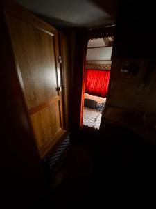 an open door to a room with a red bed at Camp pey in Saubion