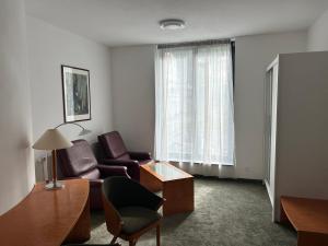 a living room with a couch and a chair at Lesní Mlýn Depandance in Mariánské Lázně