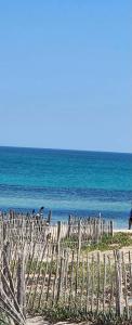 a wooden fence on a beach near the ocean at Dar el Bahri in Beni Khiar