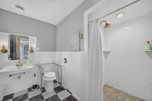 a white bathroom with a toilet and a sink at Glenside Getaway in Muskegon +70 photos