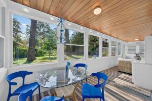 a dining room with a glass table and blue chairs at Glenside Getaway in Muskegon