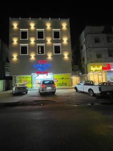 a building with cars parked in a parking lot at night at سويتات الباديه in Dammam