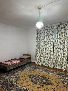 a bedroom with a bed and a window with a rug at Vintage House Aisha in Kaji-Say