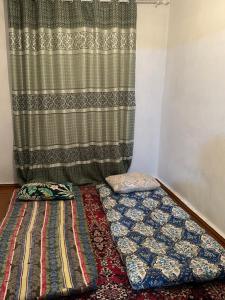 a room with two beds in front of a curtain at Vintage House Aisha in Kaji-Say