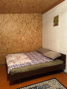 a small bed in a room with a wall at Vintage House Aisha in Kaji-Say