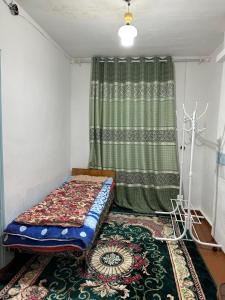 a small room with a bed and a curtain at Vintage House Aisha in Kaji-Say