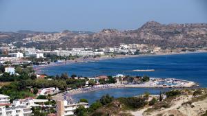 a view of a beach with buildings and the ocean at Venezia Sea Side Suites in Faliraki