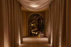 a hallway with curtains and a wall with a rock at Nômade Temple Madrid in Madrid