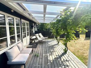 a patio with a couch and chairs on a deck at M27-Vaeggerlose-Tornbladvej-14 in Bøtø By +7 photos