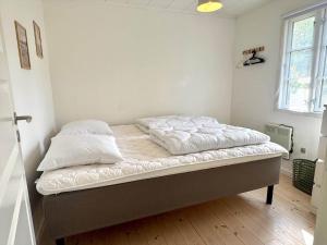 a bed with white sheets and pillows in a room at M27-Vaeggerlose-Tornbladvej-14 in Bøtø By