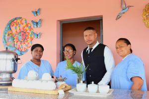 a group of people standing around a table with a cake at Hostal Santa Barbara in Santo Domingo