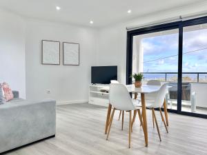 a white living room with a table and chairs at Waves Madeira II in Caniçal