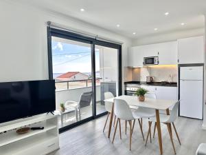 a kitchen and dining room with a table and a television at Waves Madeira II in Caniçal