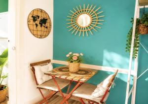 a room with a table and chairs and a mirror at Estudio con piscina y jardines a 2 min de la playa - Fuengirola in Fuengirola