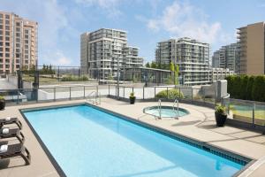 a swimming pool on top of a building with tall buildings at Vancouver Airport Marriott Hotel in Richmond