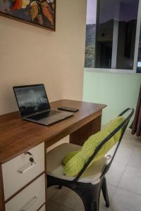 a laptop computer sitting on a desk with a chair at Torogoz Home in San Salvador
