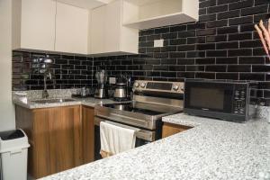 a kitchen with a stove and a microwave at Torogoz Home in San Salvador