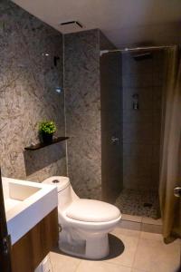 a bathroom with a shower and a toilet and a sink at Torogoz Home in San Salvador