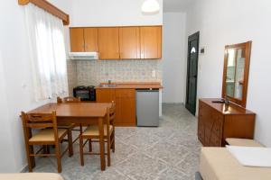 a kitchen with wooden cabinets and a table and chairs at Hotel Agios Athanasios in Ammoudia +22 photos
