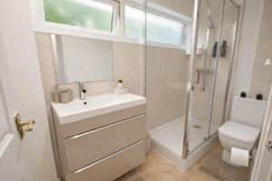 a bathroom with a sink and a shower and a toilet at Hill's View - 6 Sleeps - 10 minute walk to the town in Barnstaple +16 photos