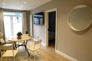 a dining room with a table and a mirror at Luxury Budget Flat in Middlesex in Colindale