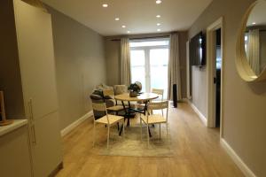 a dining room with a table and chairs and a window at Luxury Budget Flat in Middlesex in Colindale