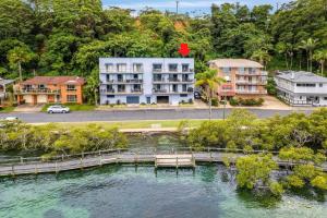 an aerial view of a house and a lake with a dock at Mountains By The Sea in Nambucca Heads