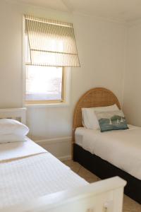 a bedroom with two beds and a window at The Mullet in Nambucca Heads