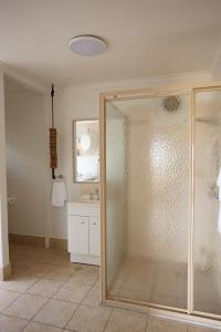 a bathroom with a glass shower and a sink at The Mullet in Nambucca Heads +33 photos