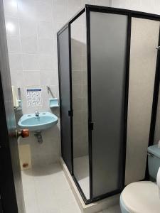 a bathroom with a shower and a toilet and a sink at Hotel Charmin in Gaira
