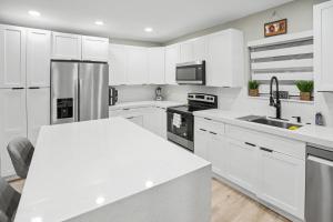 a kitchen with white cabinets and a white counter top at Mango Tree House in Hialeah