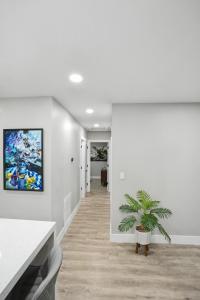 a white hallway with a potted plant in a room at Mango Tree House in Hialeah