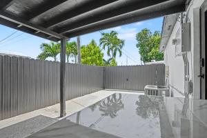 a patio with a fence and a table at Mango Tree House in Hialeah