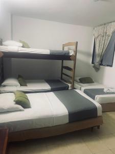 a room with three bunk beds in it at Hotel Charmin in Gaira +16 photos