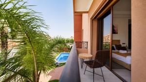 a balcony with a bedroom and a bed and a table at Villa Amroth in Marrakesh