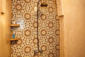 eine Dusche in einem Badezimmer mit gefliester Wand in der Unterkunft Riad 111 & Spa in Marrakesch + 47 Fotos