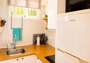 a kitchen with white cabinets and a sink at Estudio con piscina y jardines a 2 min de la playa - Fuengirola in Fuengirola
