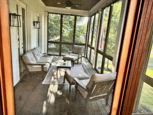 a screened in porch with couches and a table at Musician's Ranch in Franklin