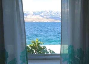 a view of the ocean from a window at Apartments Sova By the Sea in Postira