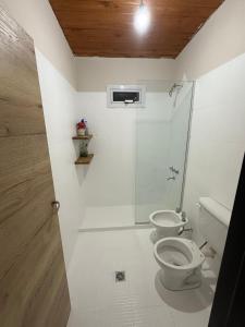 a white bathroom with a toilet and a shower at Aurora - calle Del Sol in Santa Rosa