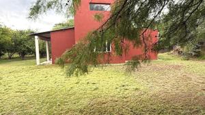 a red building with a tree in front of it at Aurora - calle Del Sol in Santa Rosa +7 photos