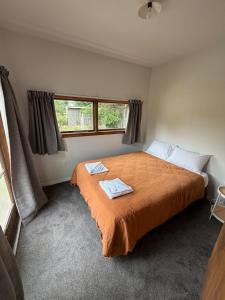 a bedroom with a bed with two towels on it at Green Views - Burkes Pass in Burkes Pass