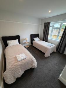 two beds in a room with a window at Green Views - Burkes Pass in Burkes Pass