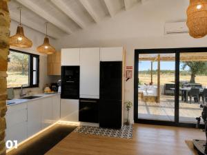a kitchen with white cabinets and black appliances at Recanto D Idjaro in Recanto