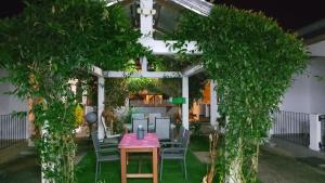 a patio with a table and chairs under a pergola at Résidence Merveilles G06 in Kribi