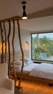a bedroom with a bed with a large window at KUBIQ 2 Transalpina in Sebeş